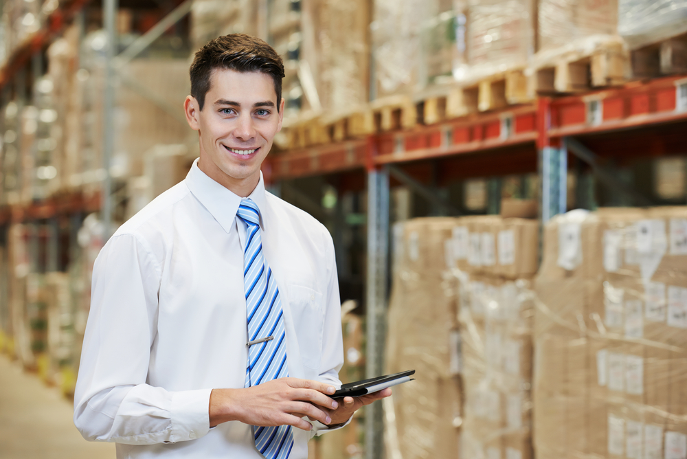 Smiling Manager in Warehouse with Tablet PC Computer