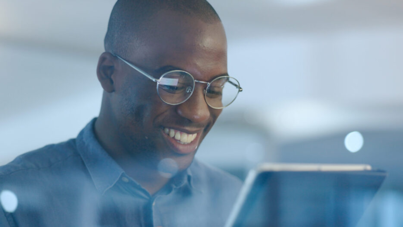 Networking, smile and black man in office on tablet for web design ideas, online project and websit.
