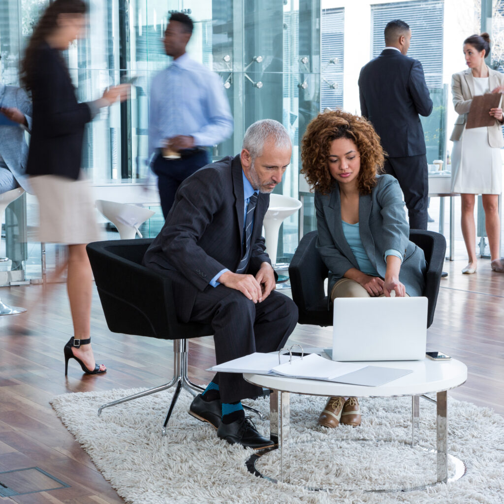 Business team discussing work over a laptop in a modern office.