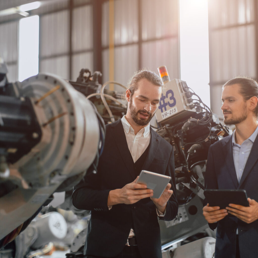 Businessman working in robotic factory using Manufacturing Software Systems