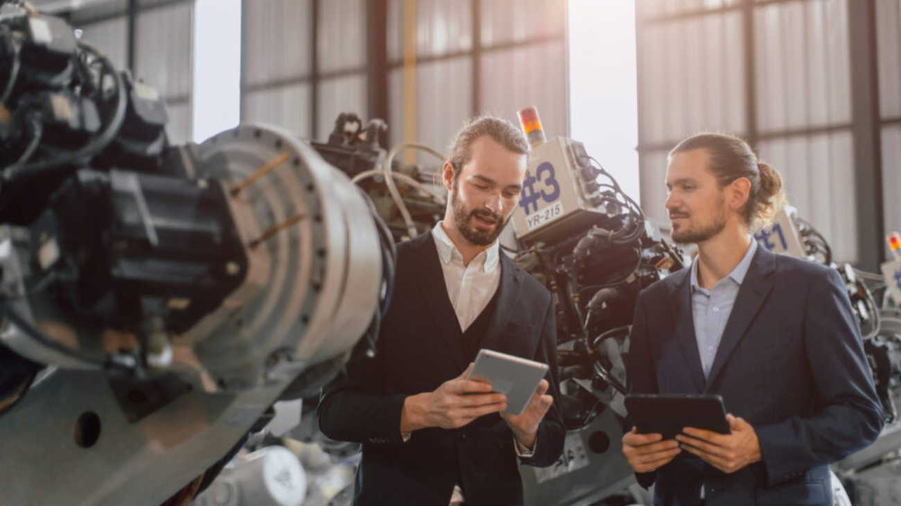 Businessman working in robotic factory using Manufacturing Software Systems