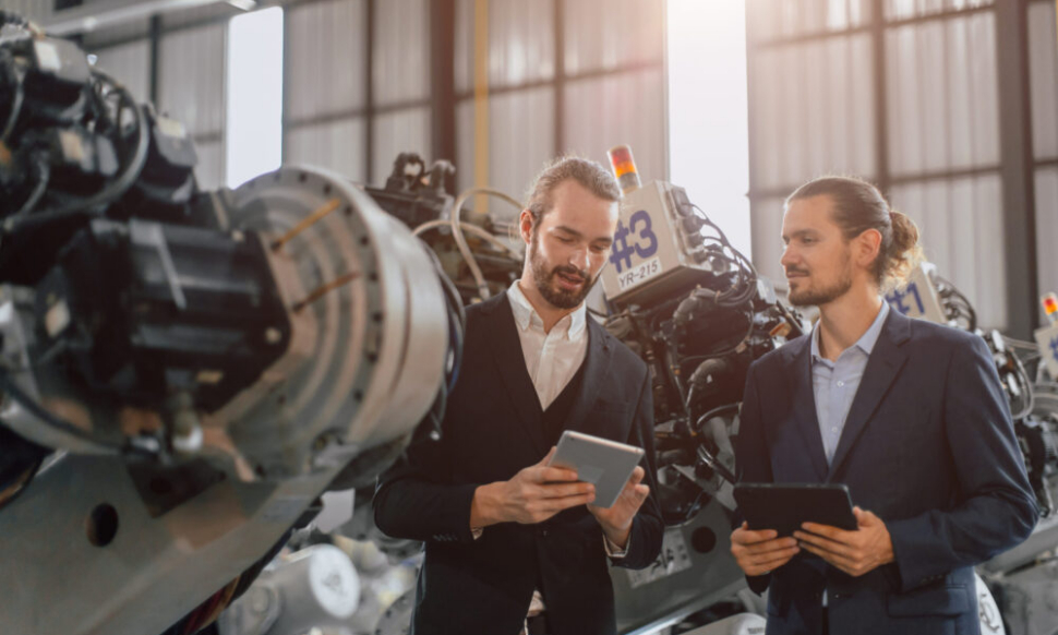 Businessman working in robotic factory using Manufacturing Software Systems