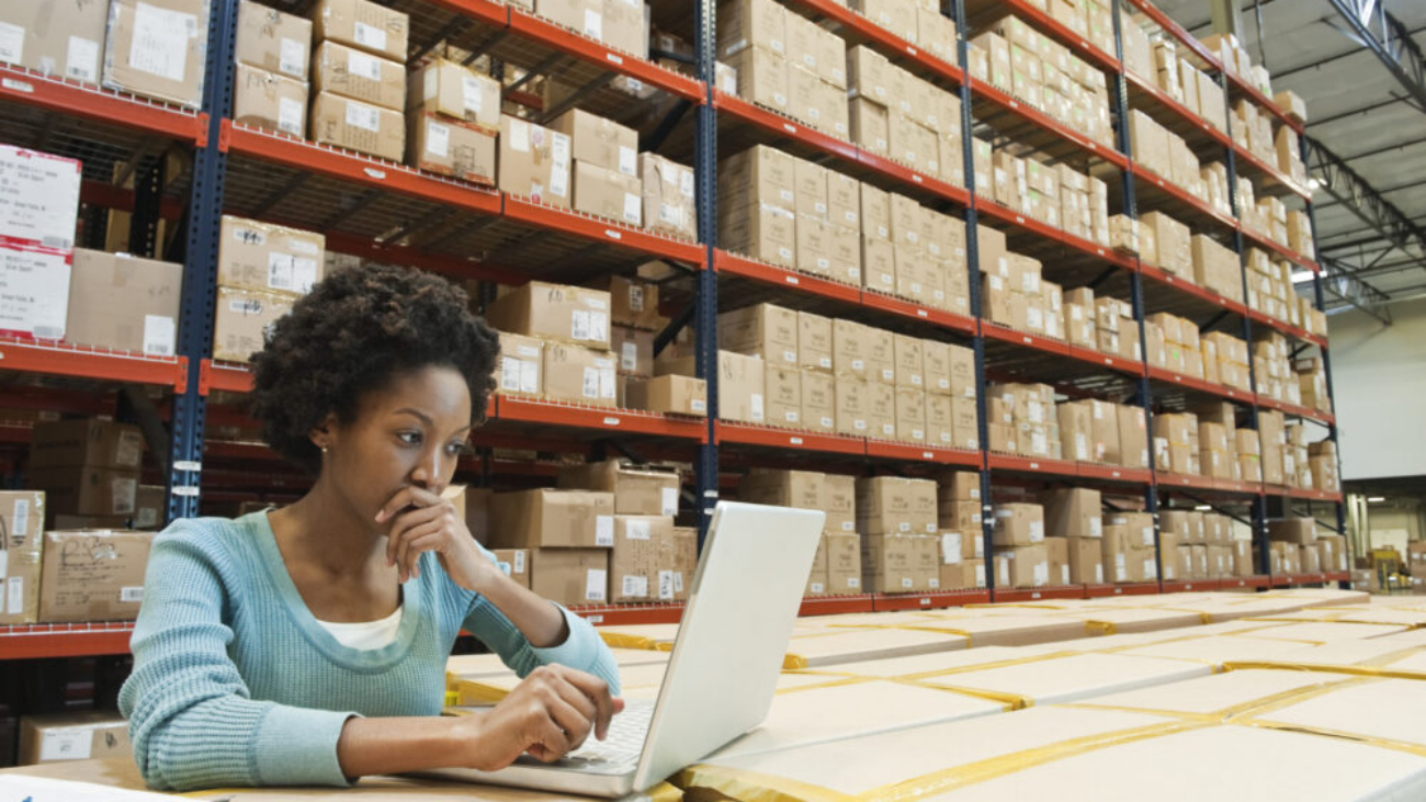 Female warehouse worker using a laptop to manage ERP operations
