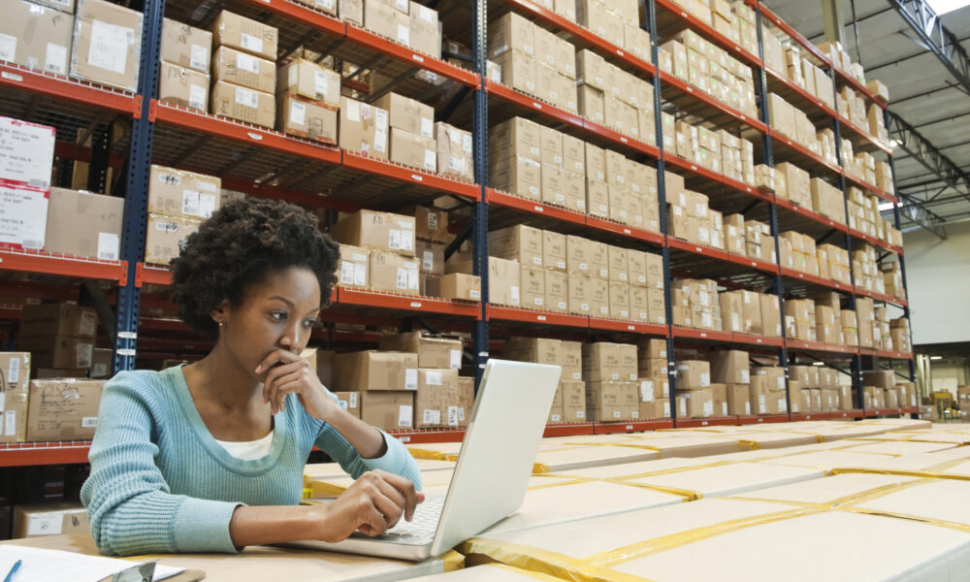 Female warehouse worker using a laptop to manage ERP operations