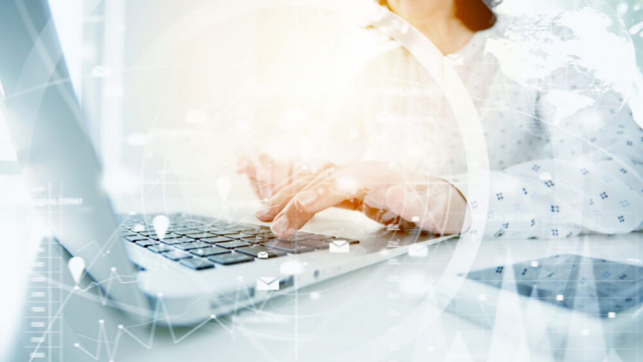Woman typing on laptop with data overlay showing AI powered accounting software and accounting ai software insights for Irish businesses.