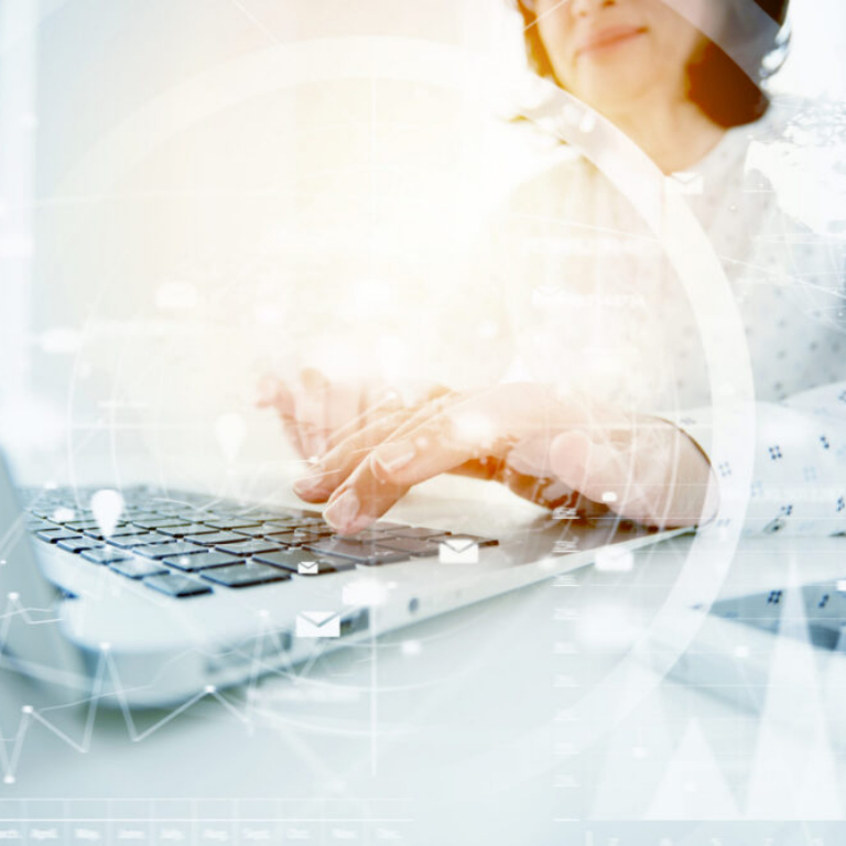 Woman typing on laptop with data overlay showing AI powered accounting software and accounting ai software insights for Irish businesses.