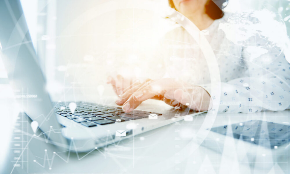 Woman typing on laptop with data overlay showing AI powered accounting software and accounting ai software insights for Irish businesses.